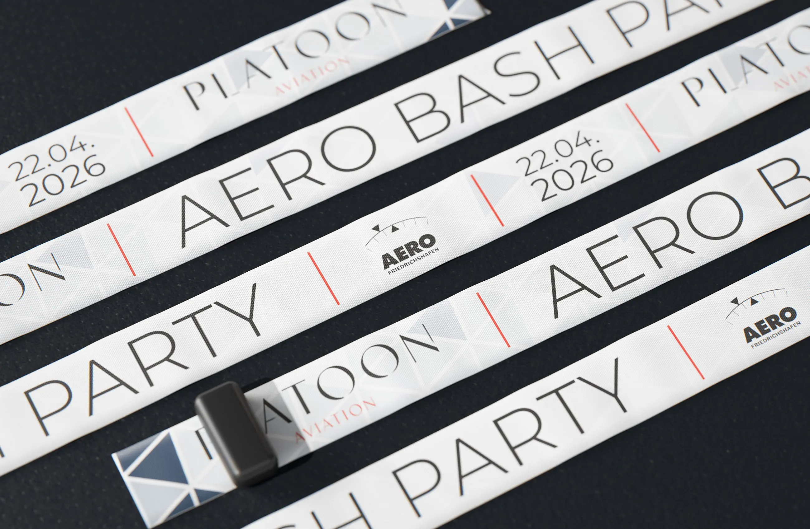 Fünf gewebte Kontrollbänder der AERO BASH Party nebeneinander, eines mit Verschluss