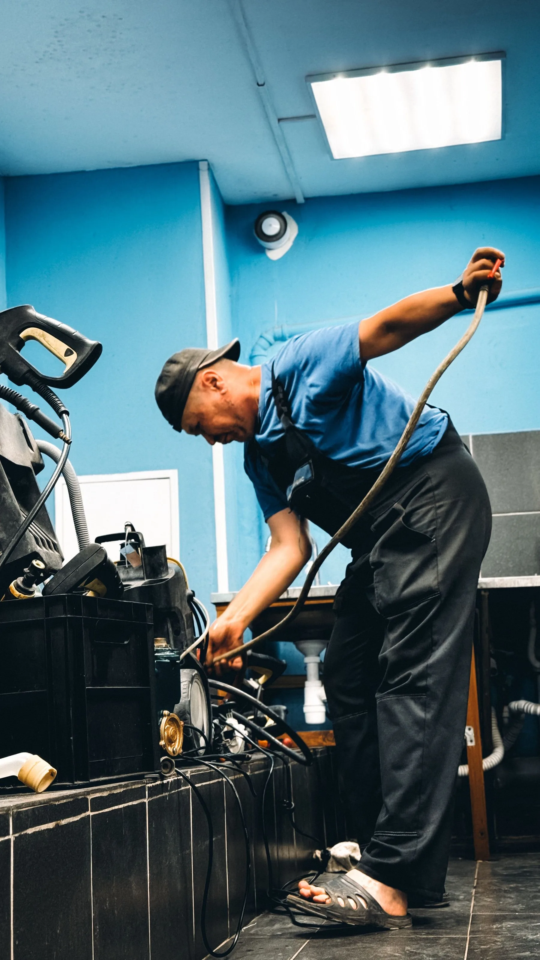 Techniker in blauer Arbeitskleidung bei der Arbeit an einer Anlage