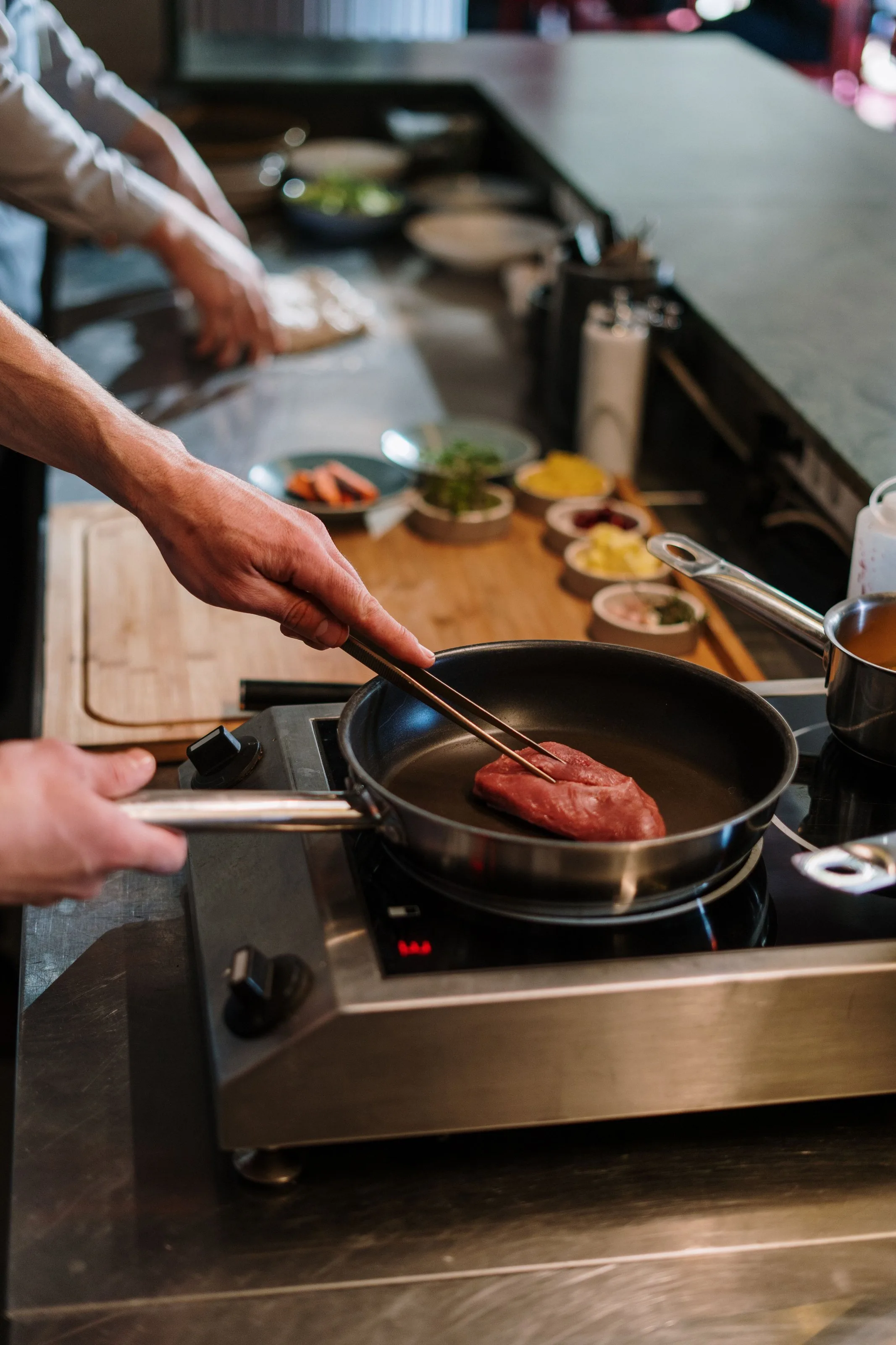 Koch brät ein Steak in der Pfanne