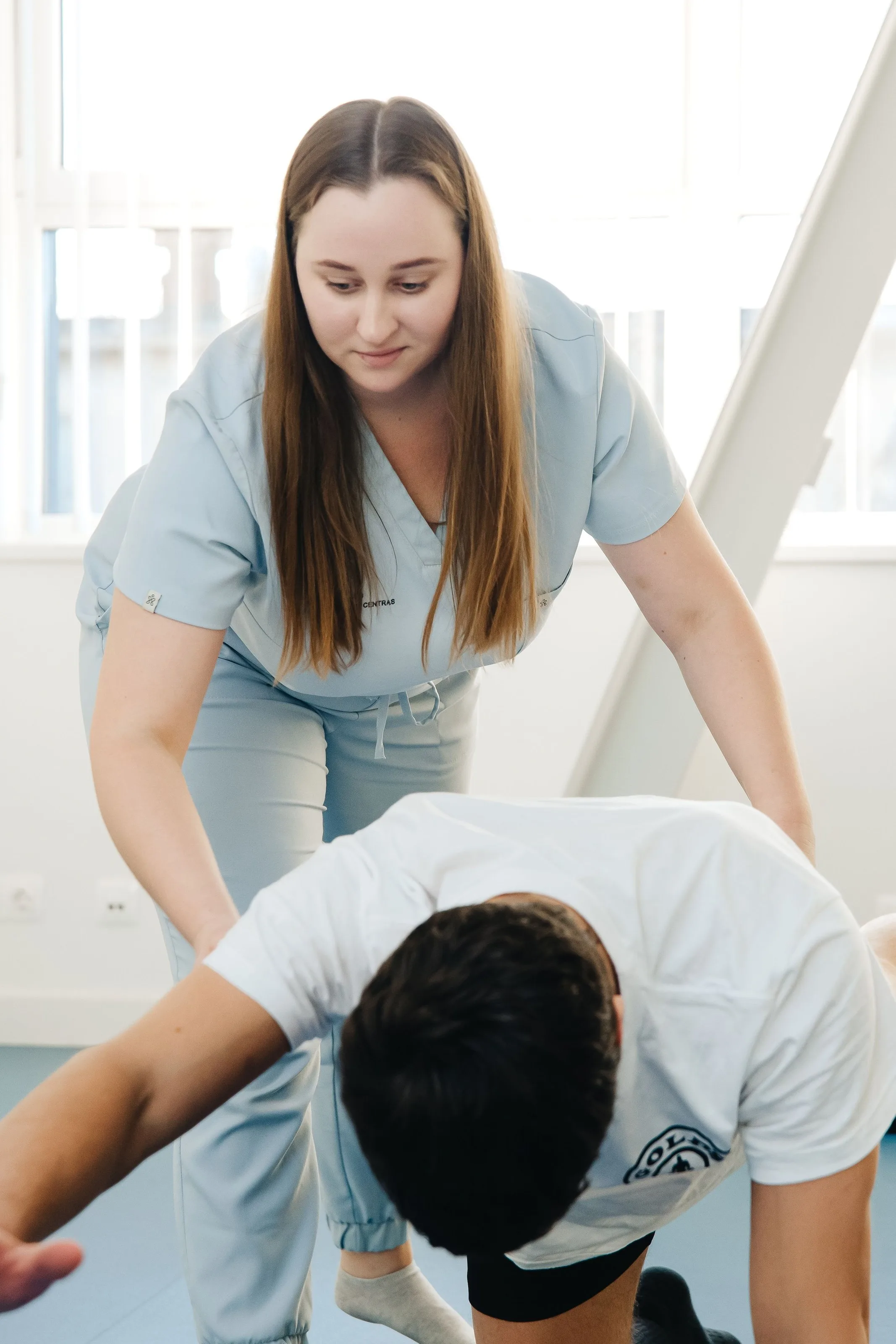 Physiotherapeutin begleitet eine Übung
